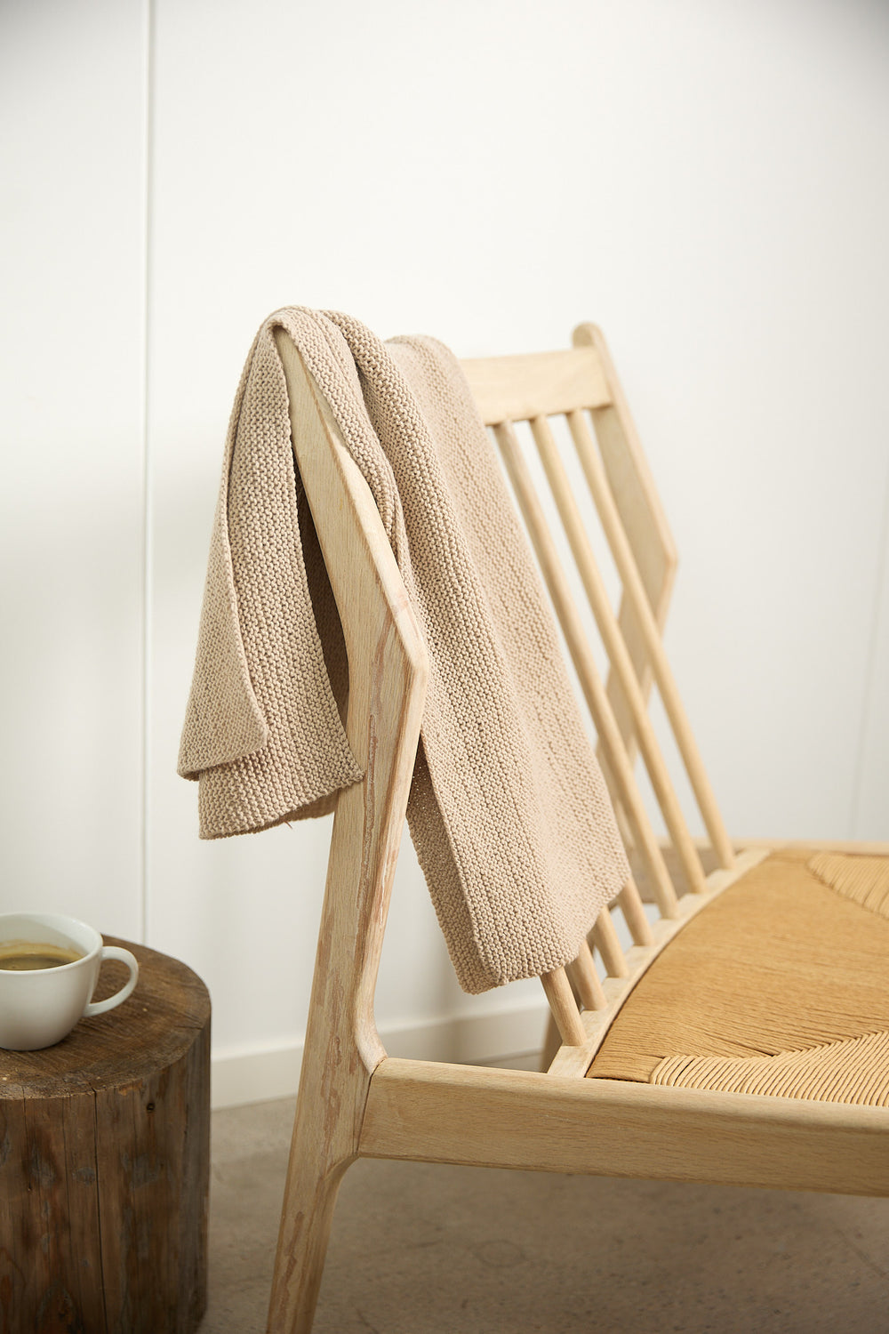 Large Handfulness kit in Sand: a ball of beige yarn, wooden needles, a cotton bag and a kraft box.